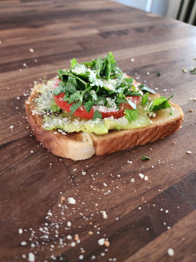 Avocado toast with tomatoes, cilantro, parmesan cheese