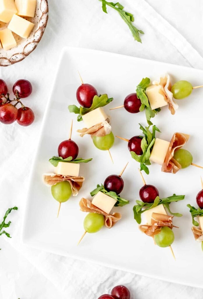 Cheese and grape skewers with prosciutto and arugula, an elegant New Year’s Eve food idea and appetizer recipes for parties