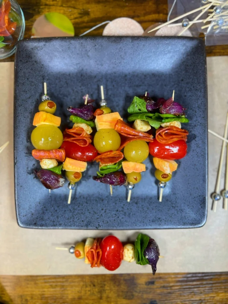 Easy charcuterie skewers with cheese, olives, and meat arranged on a marble platter for an elegant New Year’s snack.