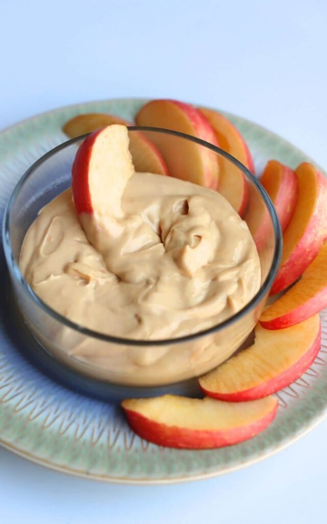 Protein peanut butter dip served with apple slices, a healthy and kid-friendly snack for New Year’s Eve celebrations.