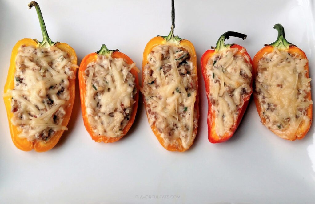 Sausage stuffed sweet mini peppers garnished with fresh herbs, a warm and hearty snack idea for the New Year.