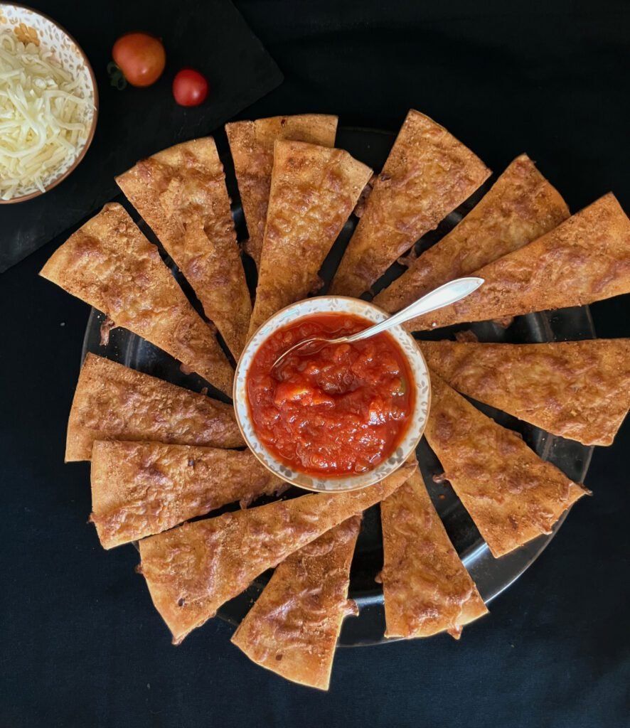 Spicy pizza dough crackers with mozzarella on a party platter, paired with marinara sauce, a savory snack idea for New Year’s Eve.