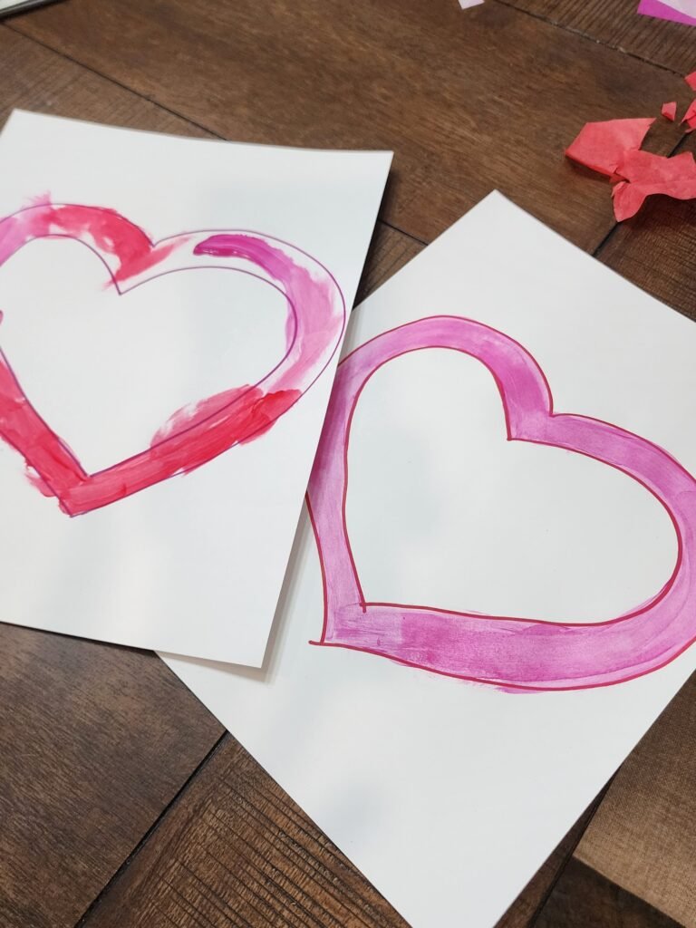 Painted heart outline drying before assembling a tissue paper sun catcher