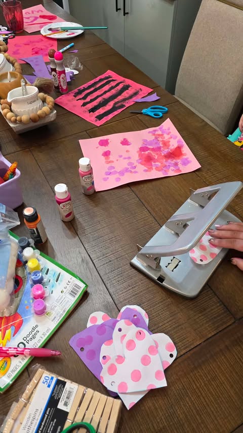 Punching Holes at the Top of Each Valentine's Heart for Banner