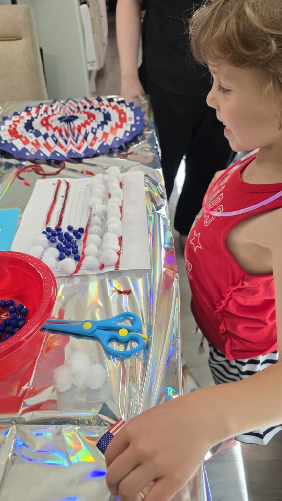 Carolynn placing cotton balls on the stripes of her flag