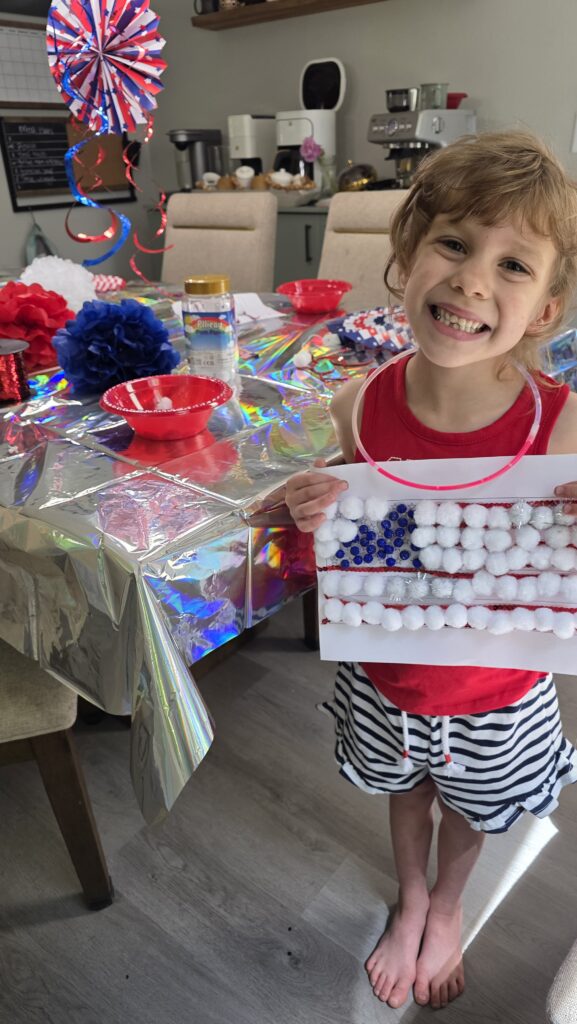 Carolynn posing with her finished craft and wearing a big smile